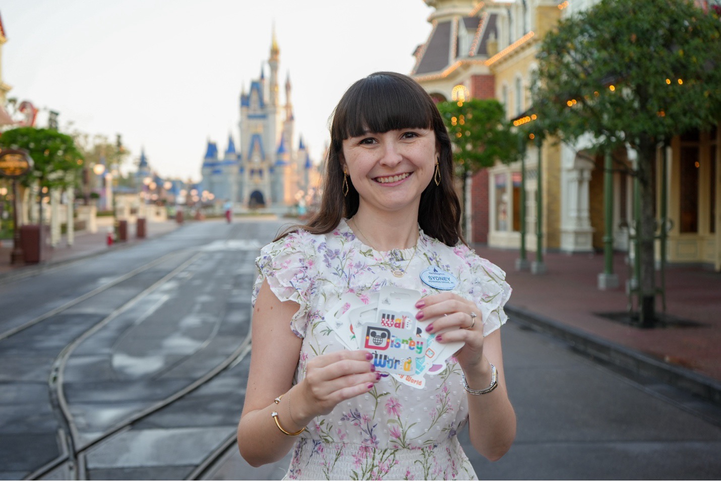 Sydney smiling on Main Street holding the magnets she designed.