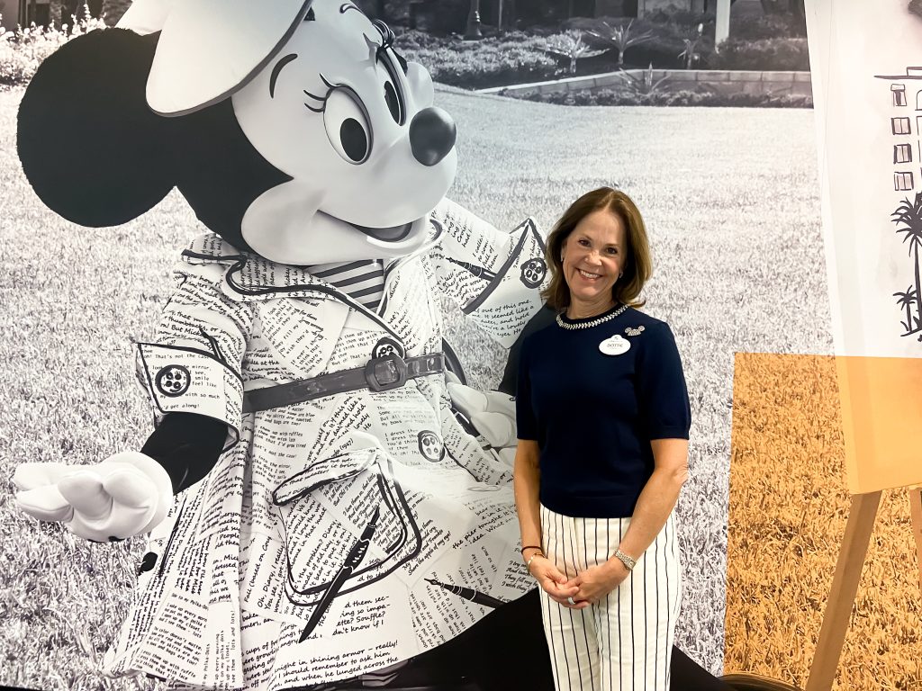 Dottie standing in front of a large photo of Minnie Mouse.