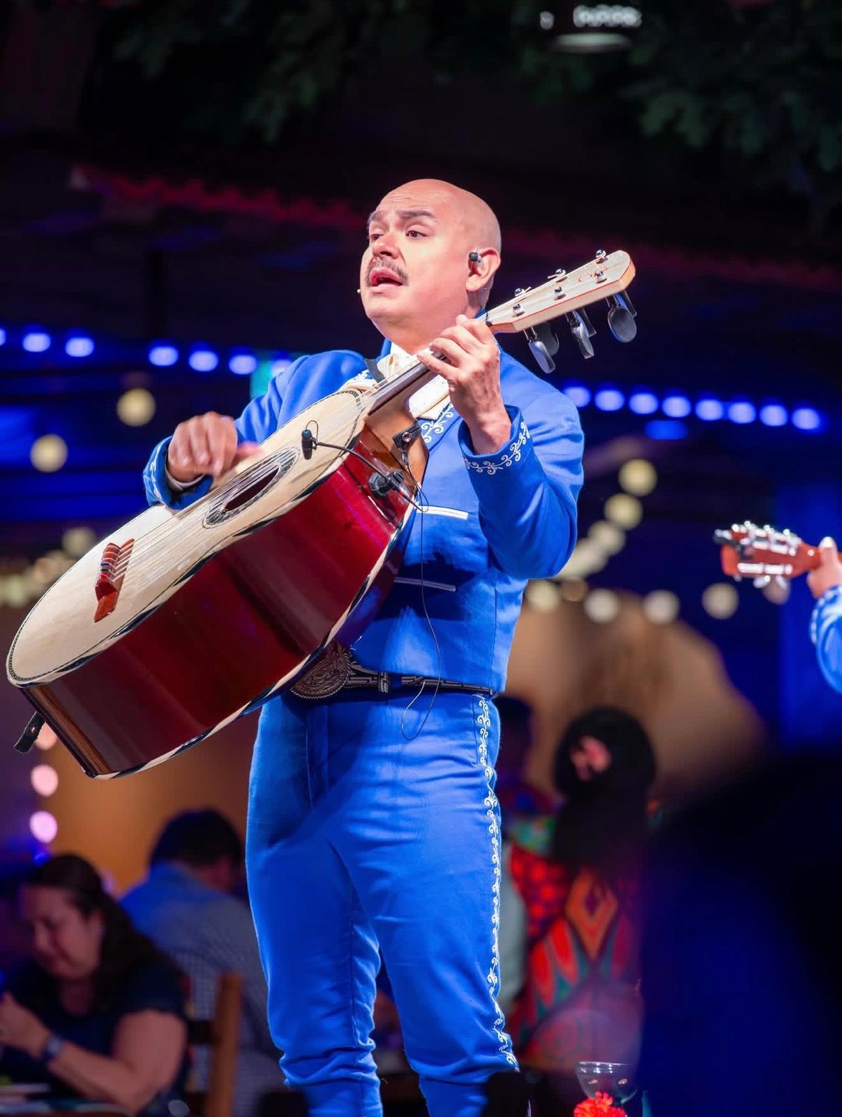 Performer playing the guittar&oacute;n in a blue suit on Disney Cruise Line