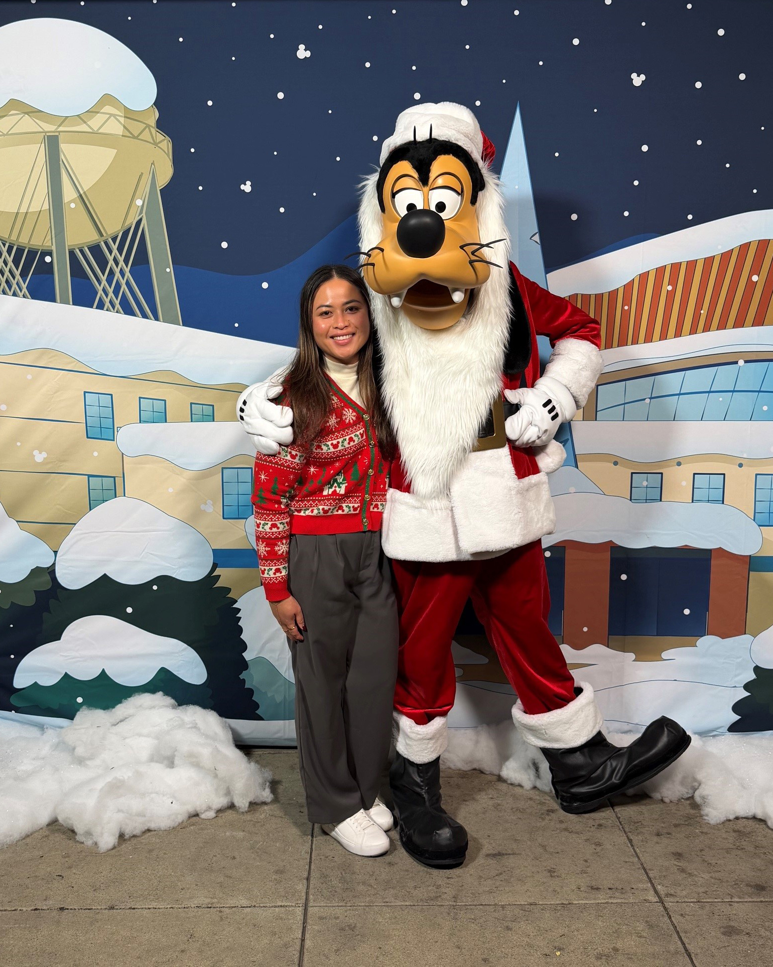 Disney recruiter Marjorie poses with Santa Goofy at a holiday event, reflecting the employee experiences, culture and community that help shape careers at Disney.