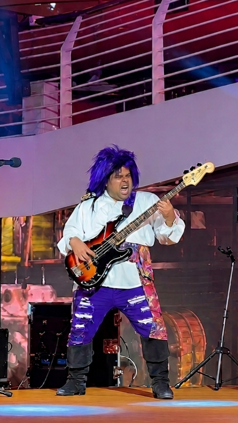 Photo of bass guitarist in a blue wig performing on Disney Cruise Line