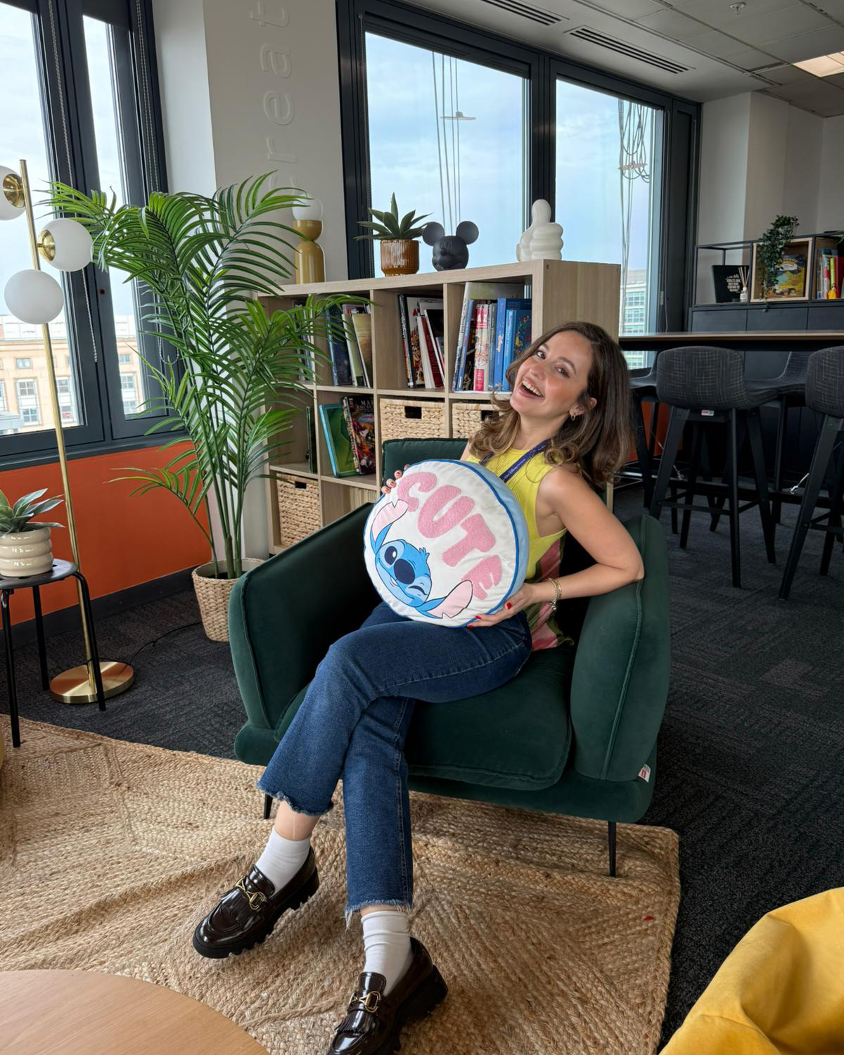 Disney recruiter Sevay sits in a collaborative Disney office space, highlighting the creative and inclusive work environment she describes when discussing careers at Disney.