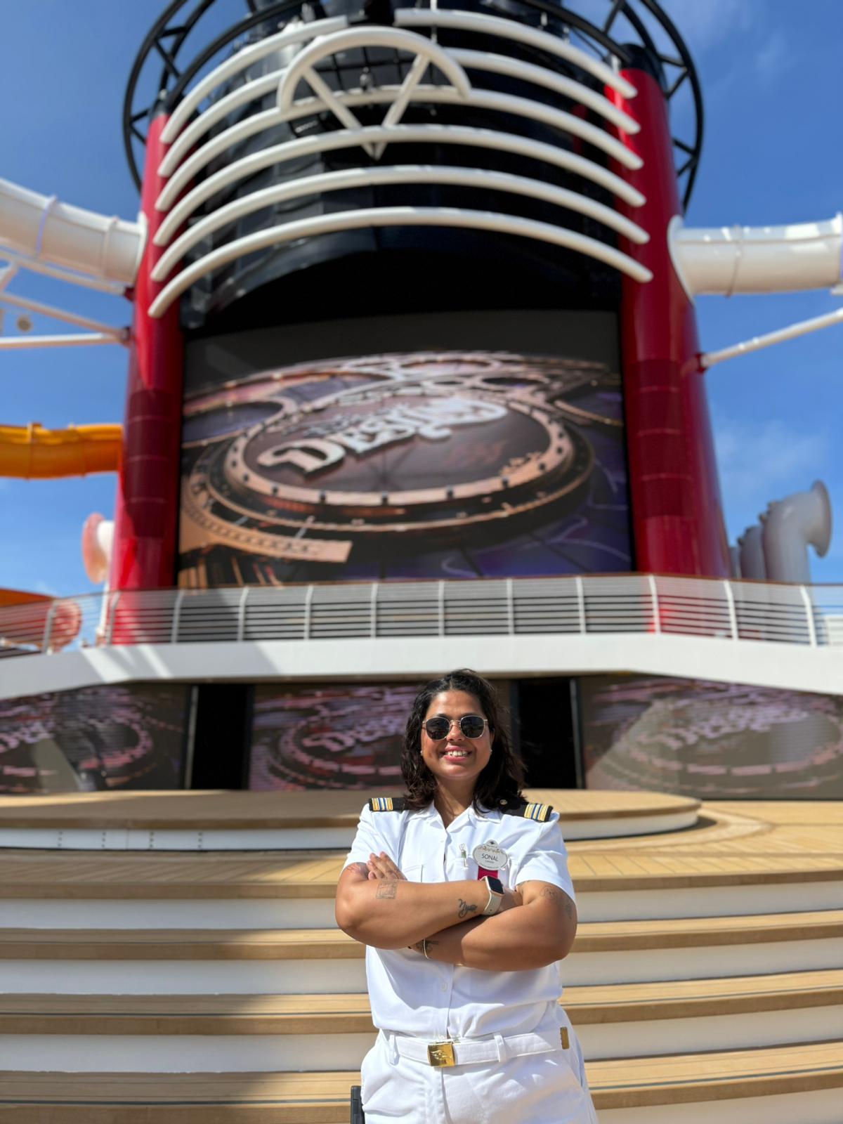 Sonal, Human Resources Manager, stands on the deck of the Disney Destiny, supporting crew members and shipboard operations at Disney Cruise Line.