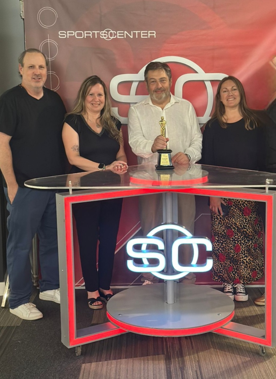 ESPN production team members gather at a SportsCenter set, reflecting the collaboration and cross-functional teamwork behind major sports media productions.