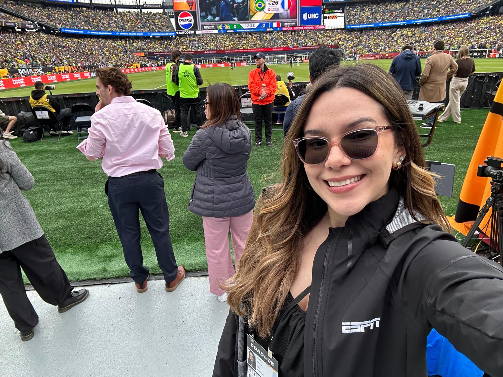 ESPN Associate Producer Mireya stands on the sidelines of a packed soccer stadium during a live sporting event, supporting major international soccer broadcasts and productions.