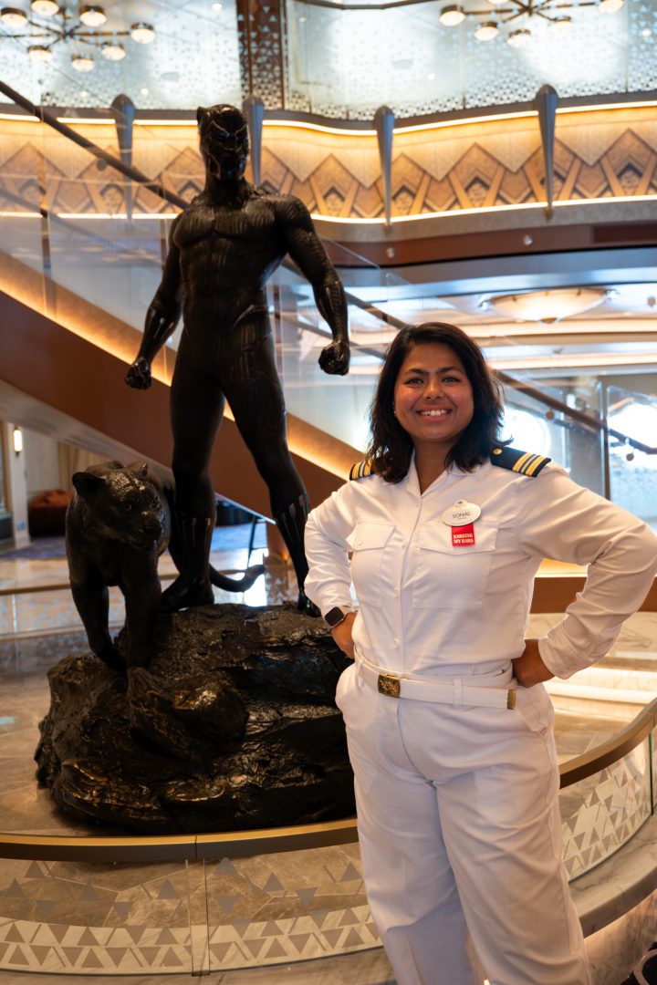 Sonal stands inside the Disney Destiny atrium, helping create an inclusive and supportive workplace culture for Disney Cruise Line crew members.