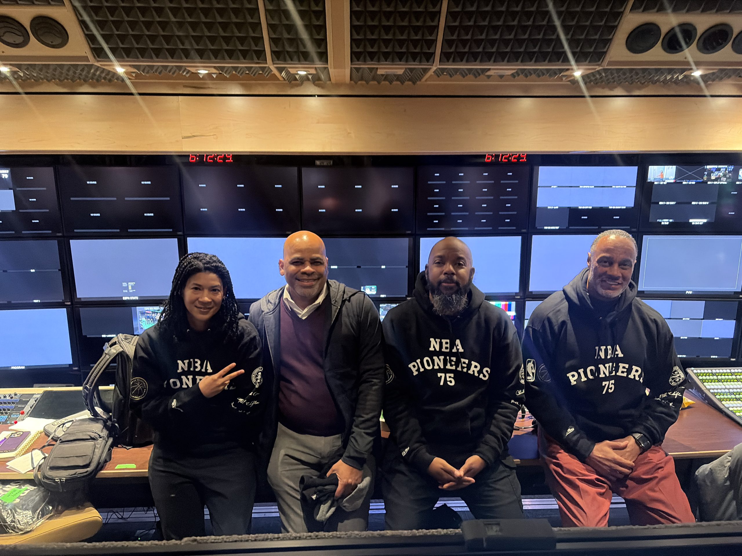 Rodney, Coordinating Producer at ESPN, collaborates with colleagues in a television production control room surrounded by broadcast equipment. The image highlights careers in sports media production, live event coverage, and ESPN operations.
