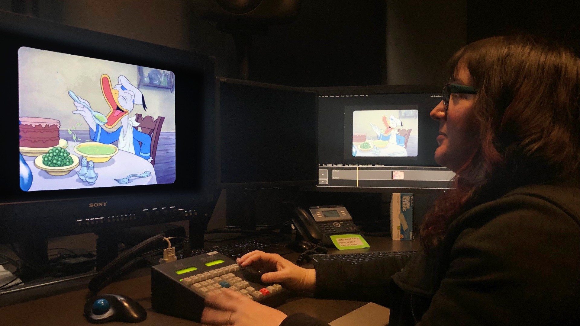 Karen, senior manager of Restoration and Preservation, reviews restored animation using studio monitors and editing controls.