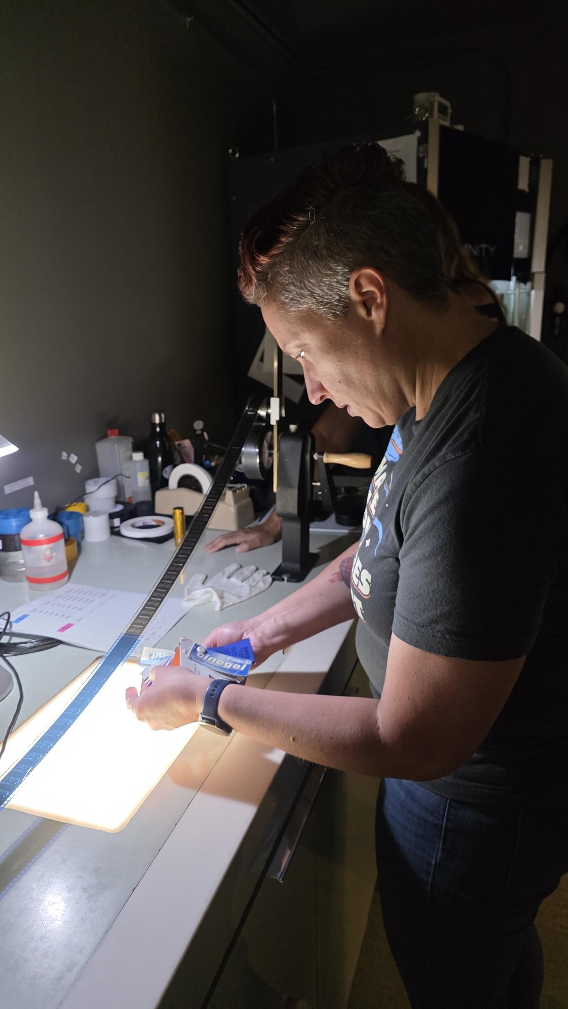 Melissa, associate project manager, examines an original film source during the Disney film restoration process.