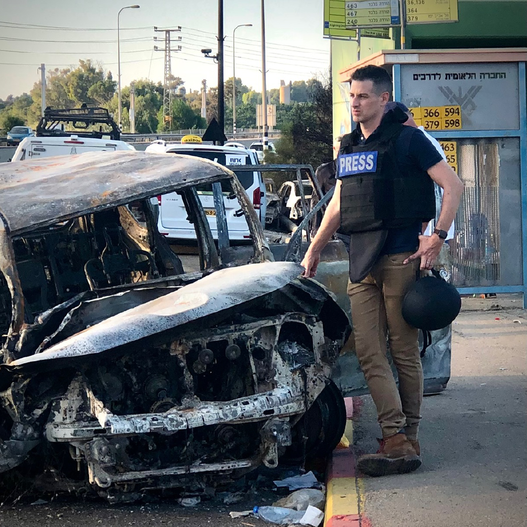 ABC News journalist Sam reports from the scene of a burned vehicle, illustrating the fast-paced breaking news environment and transportation reporting work he covers.