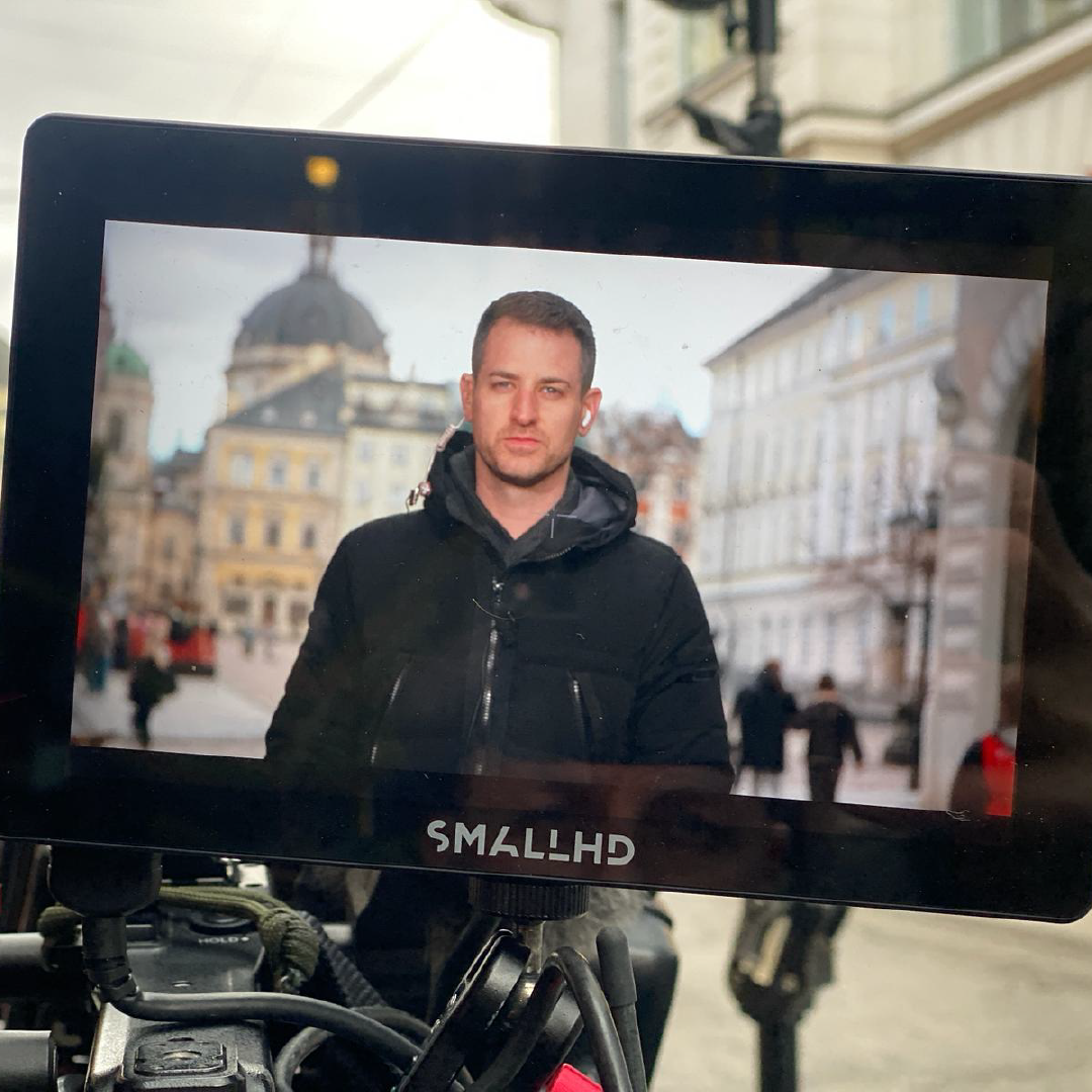 Sam appears on a field monitor during a live television news production, highlighting his work covering international stories and breaking news for ABC News.