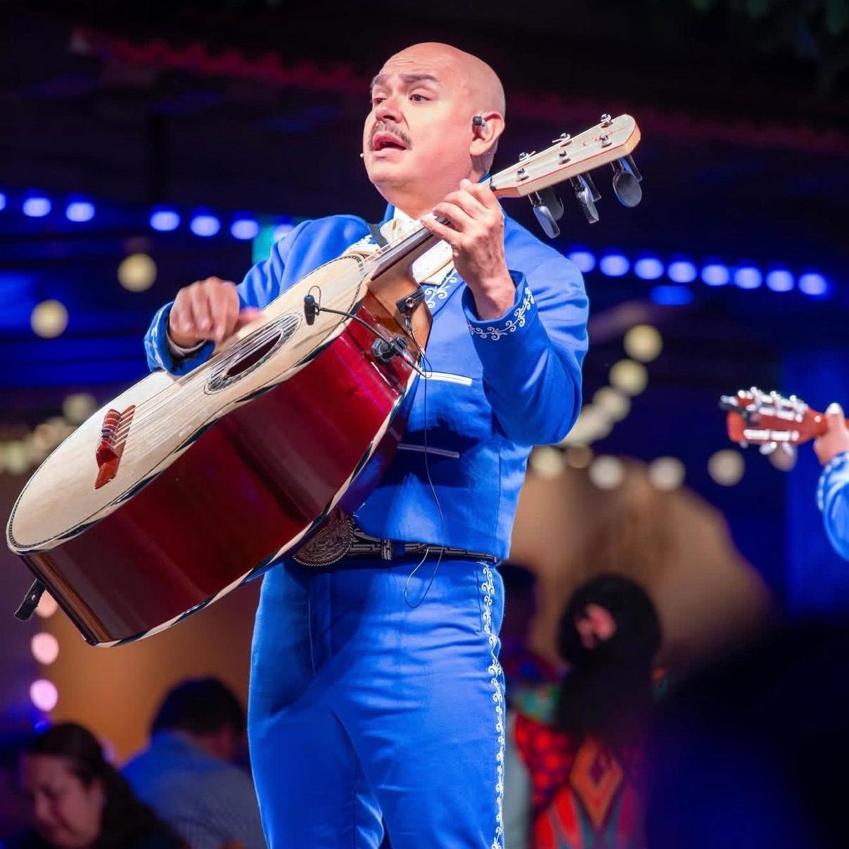 Performer playing the guittar&oacute;n in a blue suit on Disney Cruise Line
