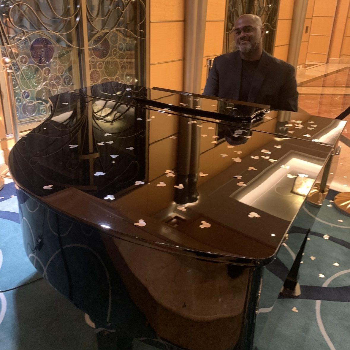 Pianist playing a grand piano on Disney Cruise Line