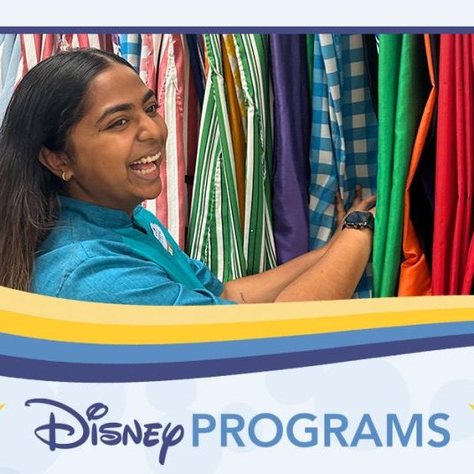 woman flipping through costume garments while smiling