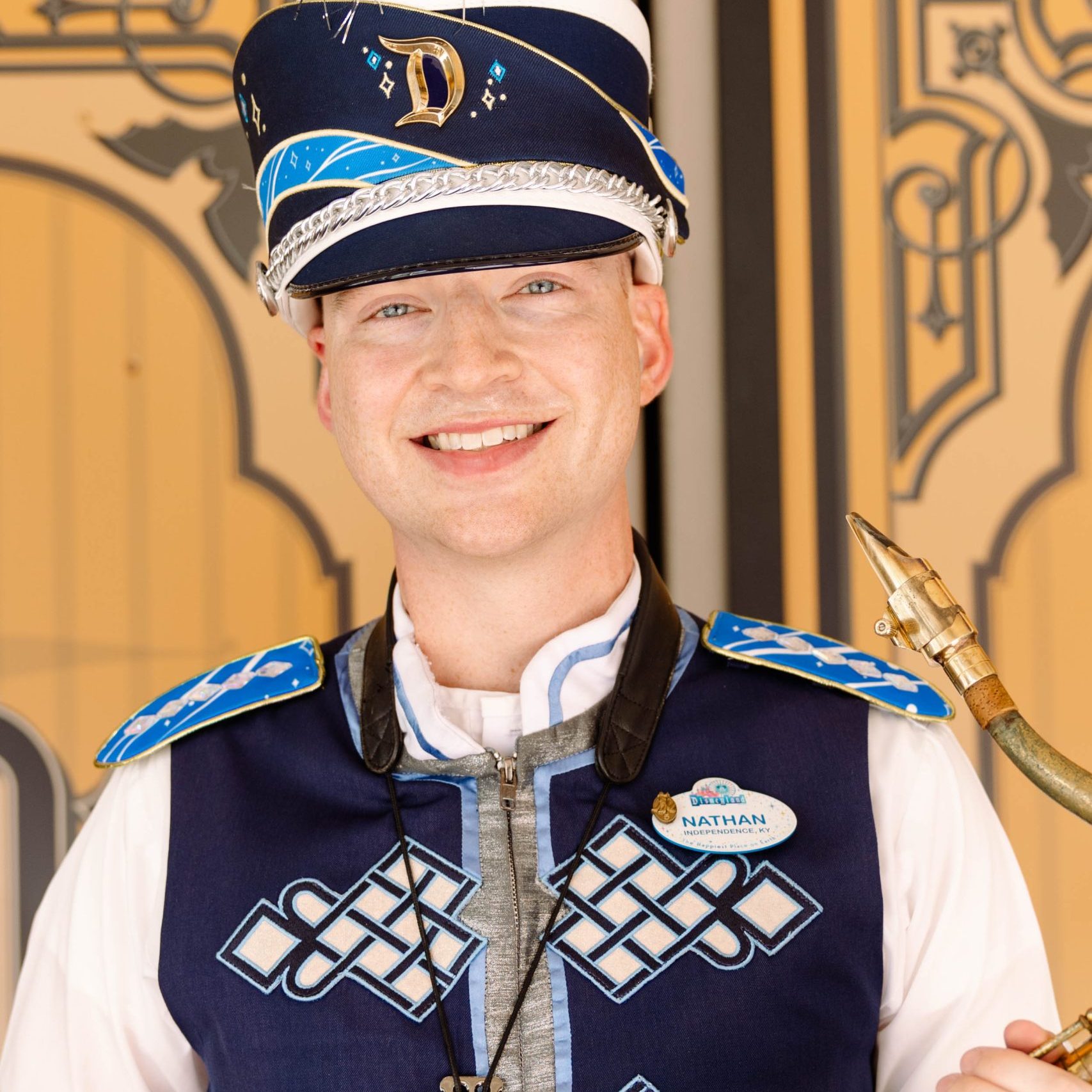 Headshot of saxophone player in front of a brown wall