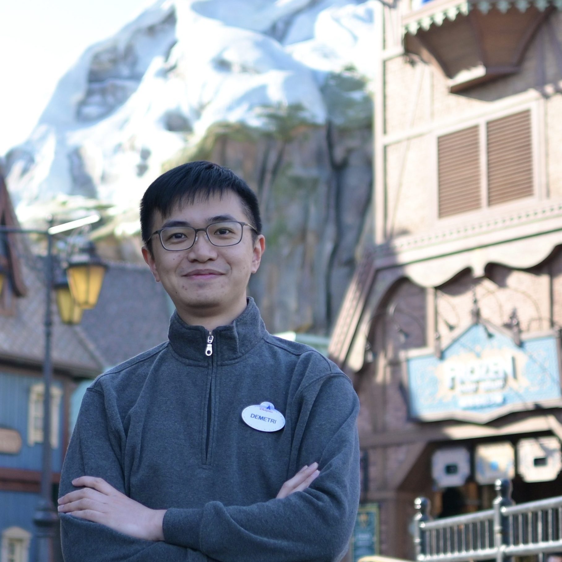 Image of employee with arms crossed in front of World of Frozen in Hong Kong Disneyland