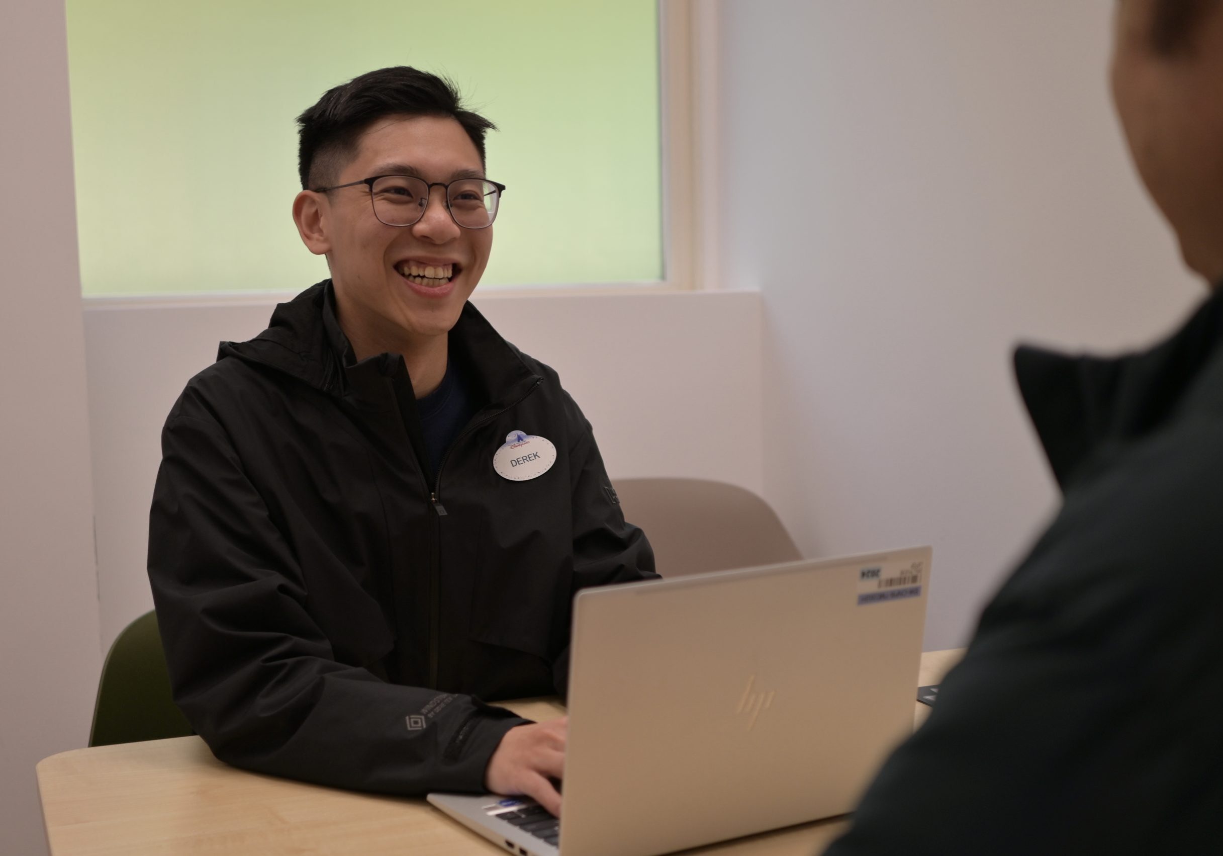 Image of employee laughing behind a laptop