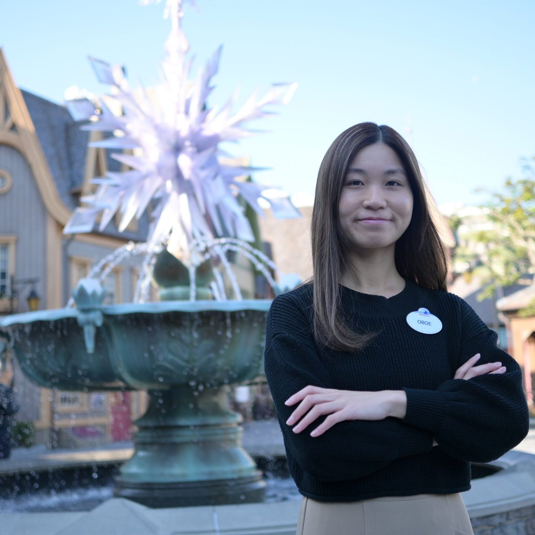 Image of employee with arms crossed in front of fountain at Hong Kong Disneyland