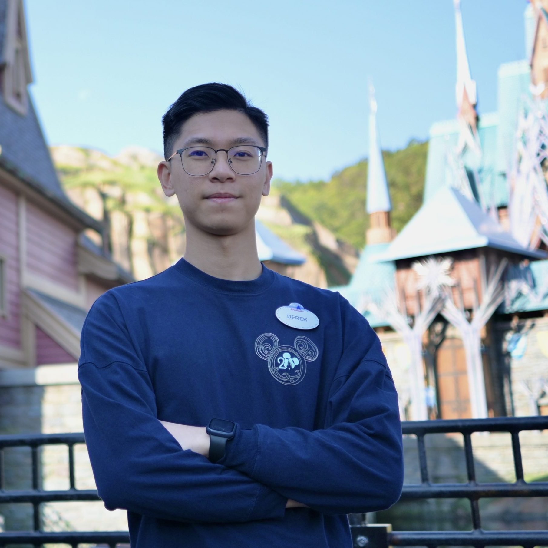 Image of employee with arms crossed in front of World of Frozen at Hong Kong Disneyland