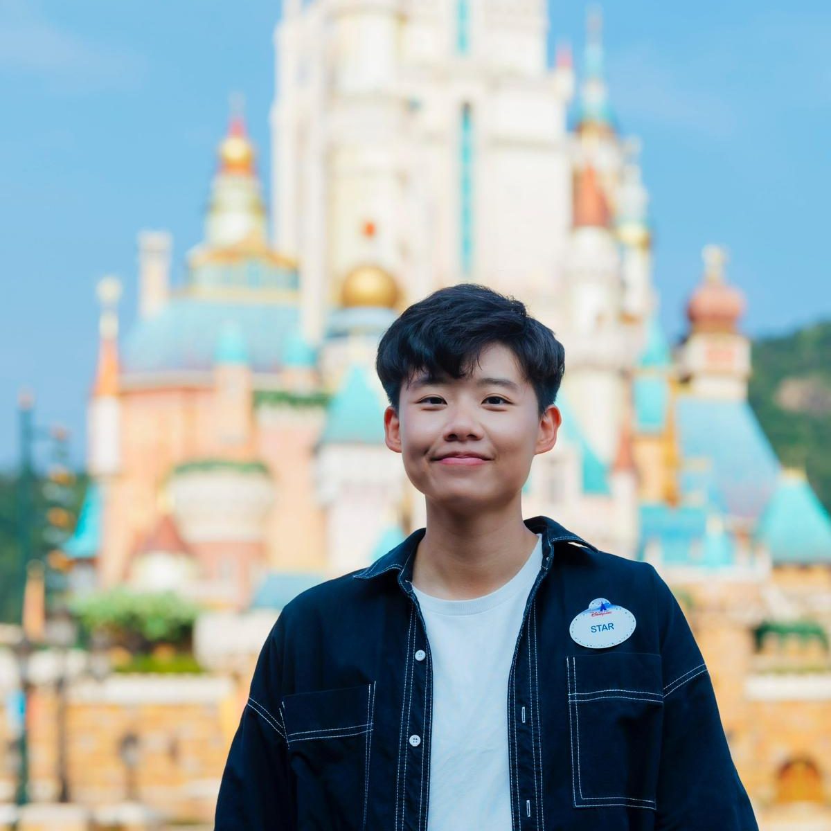 Image of employee in front of the castle at Hong Kong Disneyland