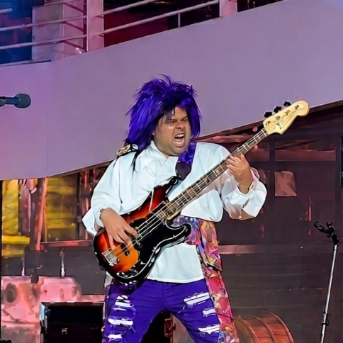 Photo of bass guitarist in a blue wig performing on Disney Cruise Line