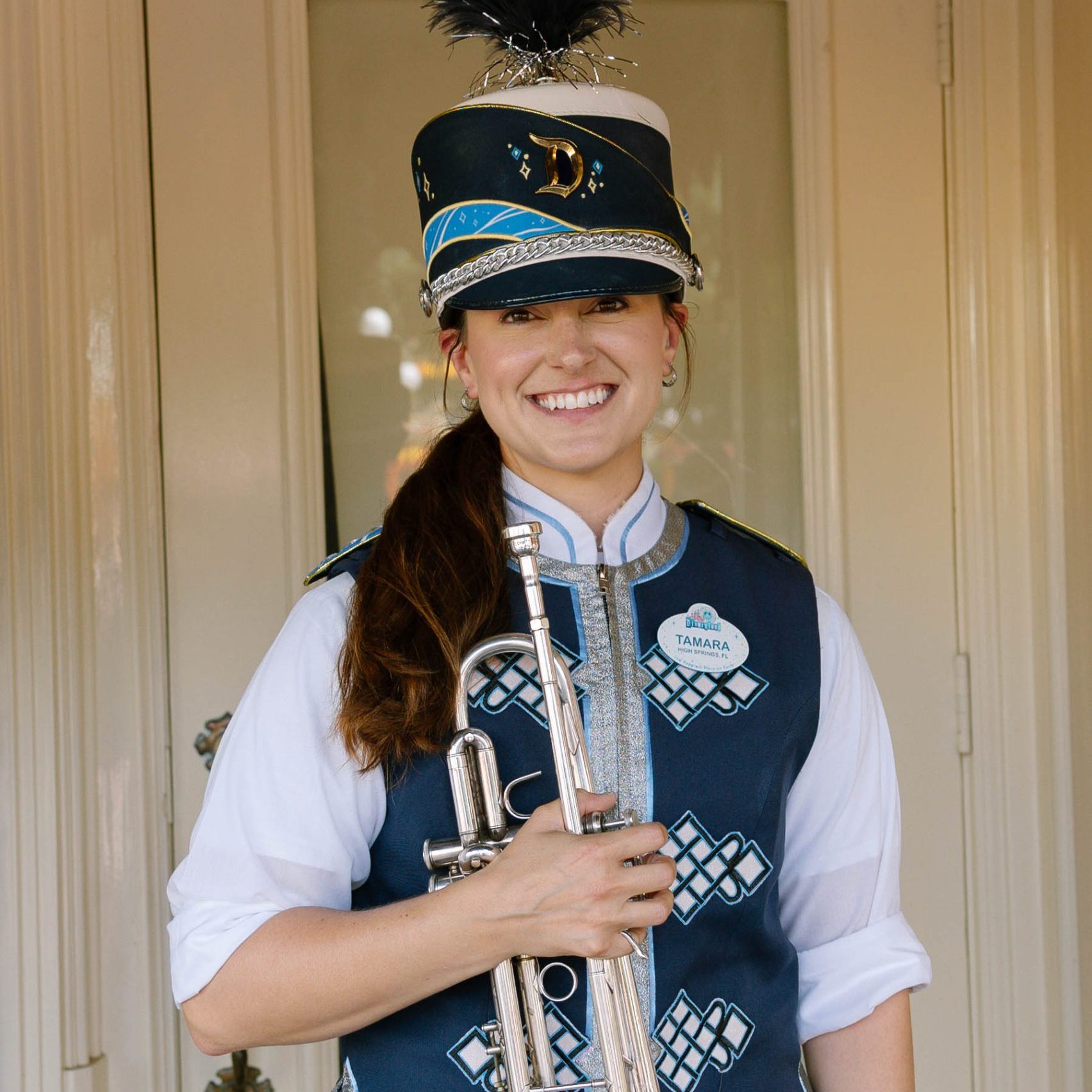Headshot of trumpet player in front of a beige wall