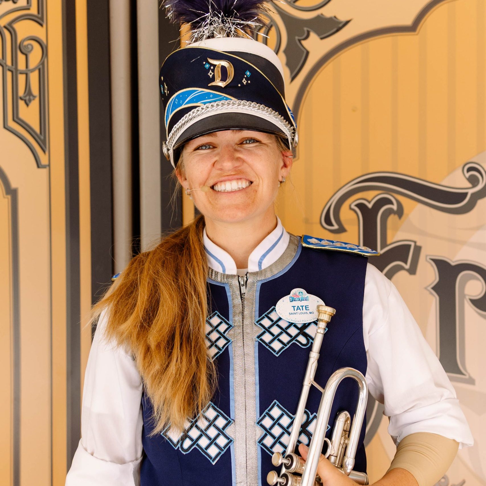 Headshot of trumpet player in front of a brown wall