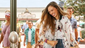 Young woman smiling and entering a Disney theme park